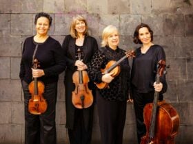 Four women Australian string musicians standing together with their instruments