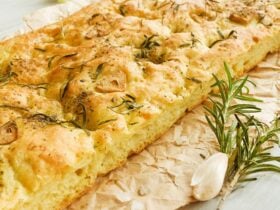 Italian focaccia bread with rosemary, garlic and olive oil on brown paper