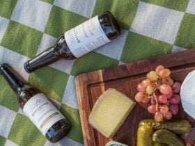 Two bottles of Daylesford Cider with cheeses