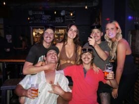 Group of friends posing with drinks inside Freight Bar.