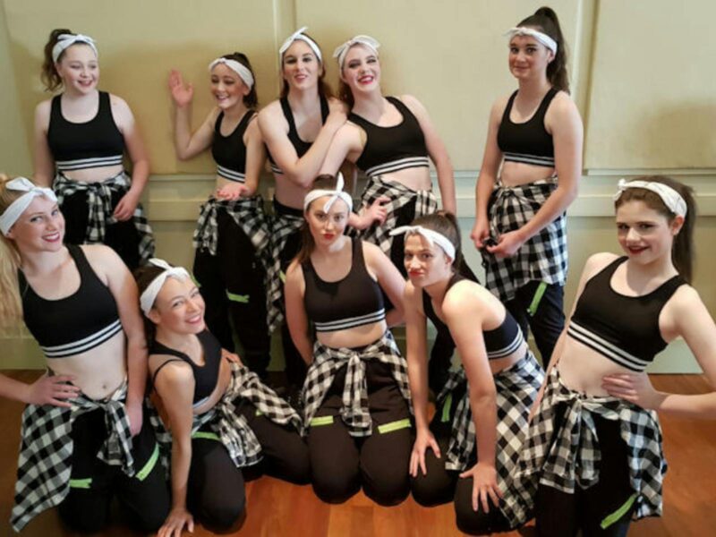 A group of ten performers posing