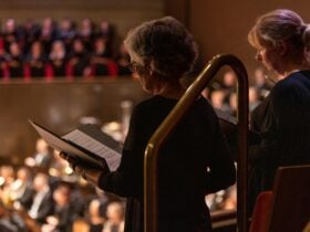 Choir members reading sheet music.