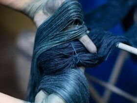 Indigo dyed yarn held in a pair of stained hands