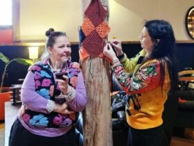Regular knitters Gwyn and Jade adding squares to the yarn bomb at the wine shed