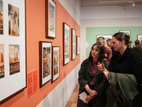 Photo shows attendees viewing works in the gallery space