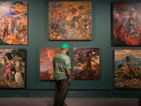 a man looking at paintings