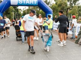 Man and Child Holding Hands Crossing the Finish Line