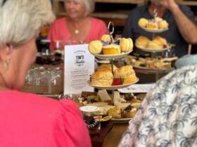 A tower of sweet and savoury treats in the middle of a table that is surrounded by people
