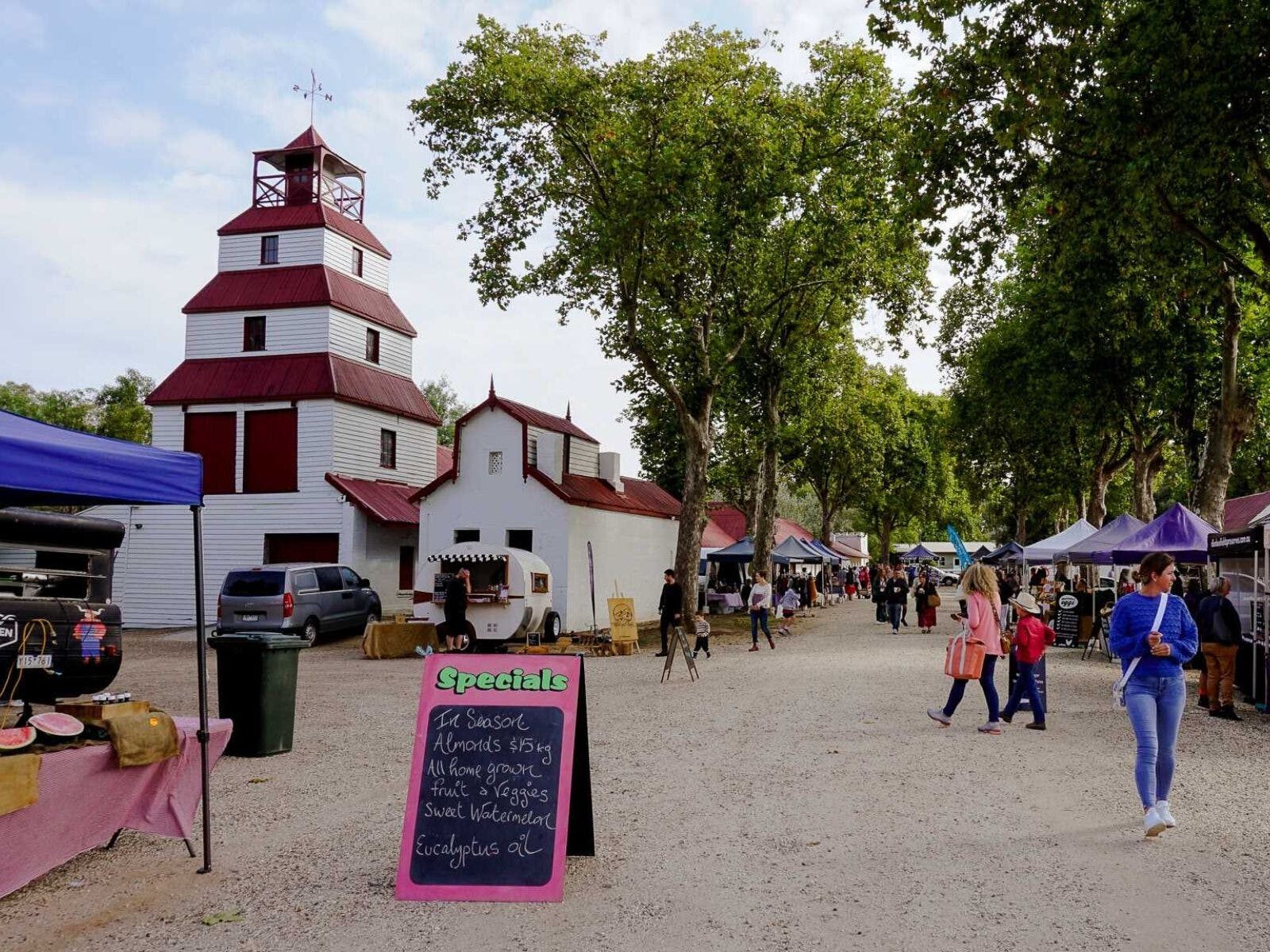 People walking in Tahbilk Cellar Yard looking at market stalls.