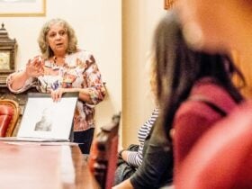 Colour photograph of a woman presenting to a crowd.