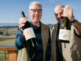 Two men holding wine bottles