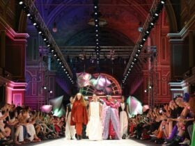 Models in bold, sculptural outfits walk down the runway for the finale