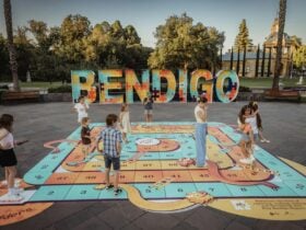 Children playing on the giant Dragons and Ladders design at the Bendigo Sign