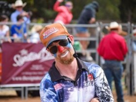 A rodeo clown smiles sarcastically at the camera