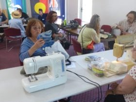View of one of our repair cafes, with sewing machine in foreground and other fixers in background