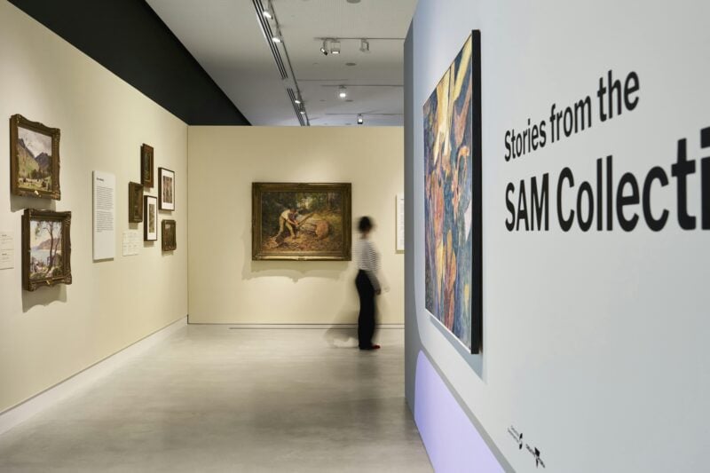 A woman walks past colonial-era paintings in an art gallery