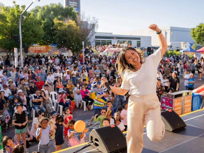 Host celebrating on stage with large crowd of people in audience