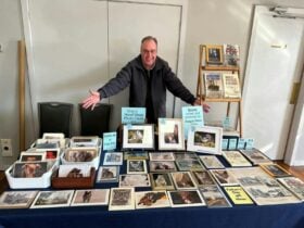 artist showcasing his artwork at a market stall