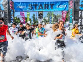 People running through the foamy start line