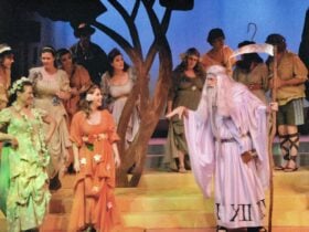 Father Time holds a sythe and addresss a maiden in a green robe and a maiden in a brown robe