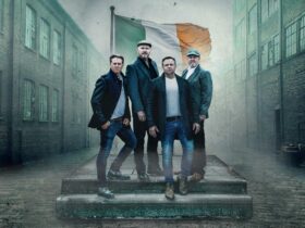 The High Kings band posing in front of Ireland flag.