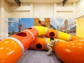 a child playing with orange and yellow tubes