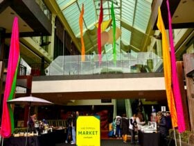 Main entry to Southgate featuring market stall and bright, colourful flags