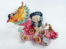 Small, brightly coloured ceramic of a woman riding a dragon