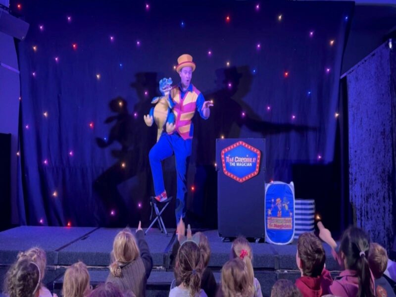 Kids watching Tim Credible perform a live magic show with Douzie the Dragon in Melbourne school holi