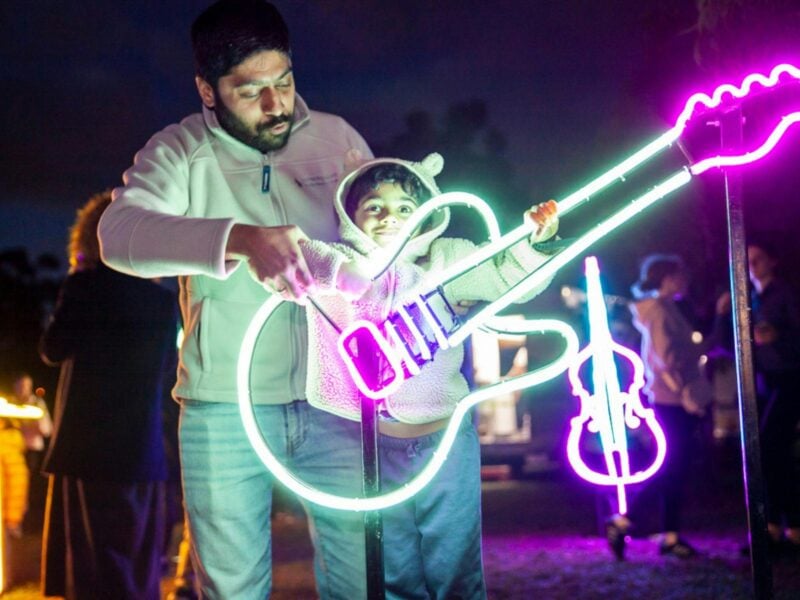 Father and child enjoying the neon light display