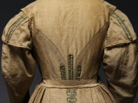 Back of 19th century light brown dress with green trimming and wide sleeves