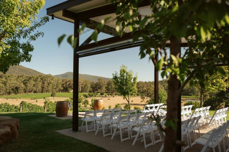 the pavillion, with views over the valley, white chairs are lined up for a wedding ceremony