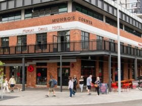 Exterior of Brick Lane Market with red brick walls and people walking by on the street