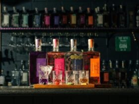 A Gin flight with bottles of gin behind
