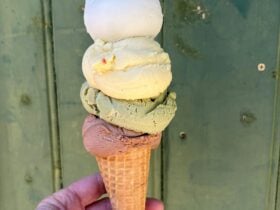 Vegan stack of white, yellow, green and pink ice cream in a cone