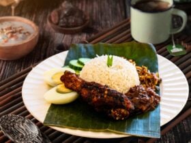 Nasi lemak with sambal, anchovies, peanuts, egg, cucumber and fried chicken.