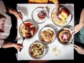 A table of dishes including Hotcakes, meatballs, calamari, breakfast burger, seafood pasta.