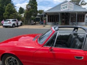 Red car in front of the Whorouly Cafe.