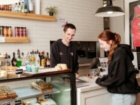 A person serving someone at a cafe counter