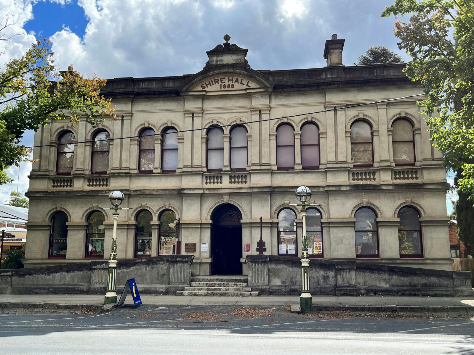 Building street view. Grand two story building with ornate lampposts at front.