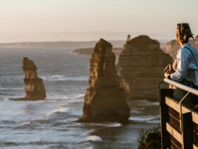 Woman stands viewing 12 Apostles Great Ocean Road Tour