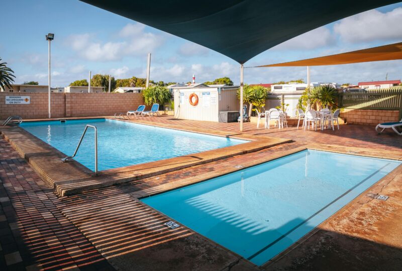A shaded swimming pool and smaller kiddie pool at Geraldton Belair Gardens Caravan Park