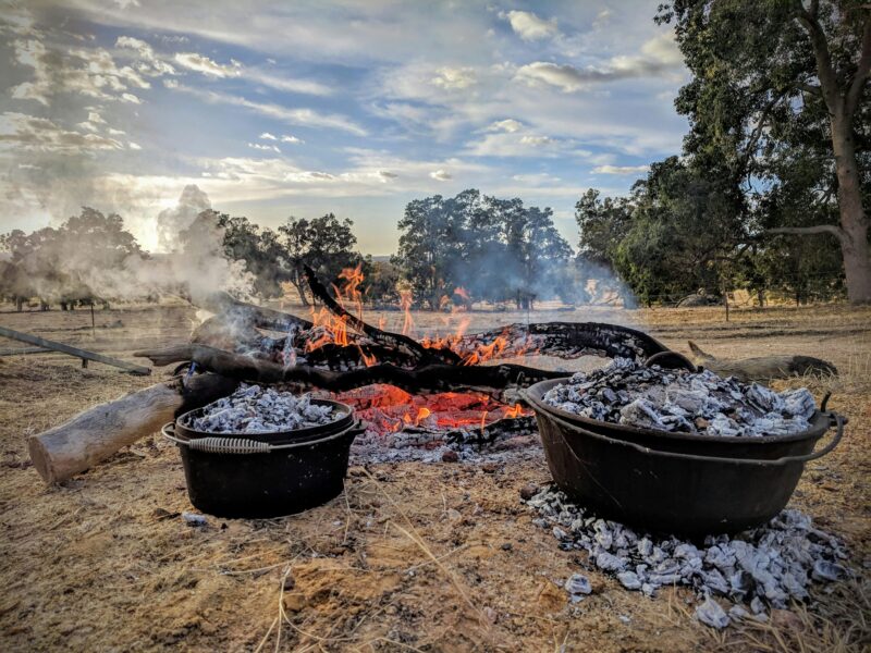 Campfire with cast-iron pots cooking in the ashes