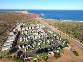 A drone photo shows a caravan park overlooking cliffs and ocean