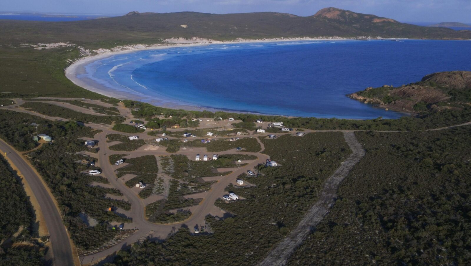 Aerial view of road and camping spaces near a bay.