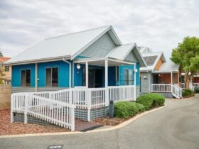 Mandurah Ocean Marina Chalets with accessible ramps, vibrant blue and orange facades.