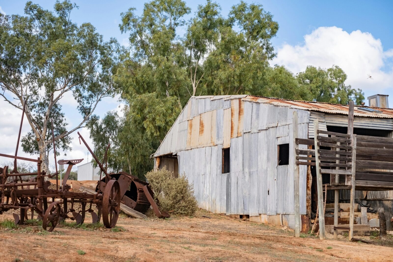 Old farm shed building with heritage farm machinery on outback station