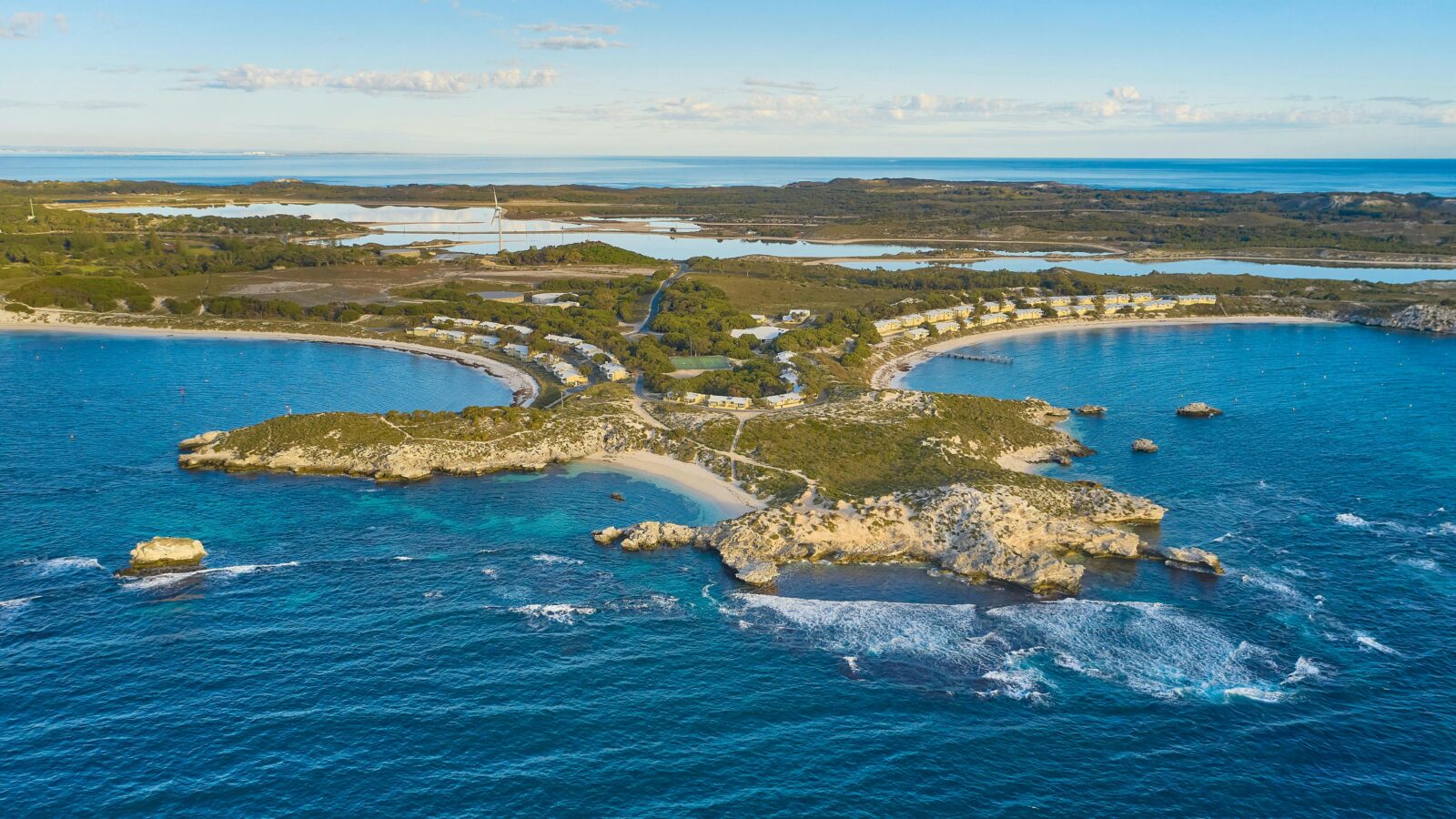 Aerial view of island with beaches, and coastal headlands.