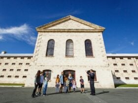 Tour guide welcomes tour group in front of Fremantle Prison Main Cell Block