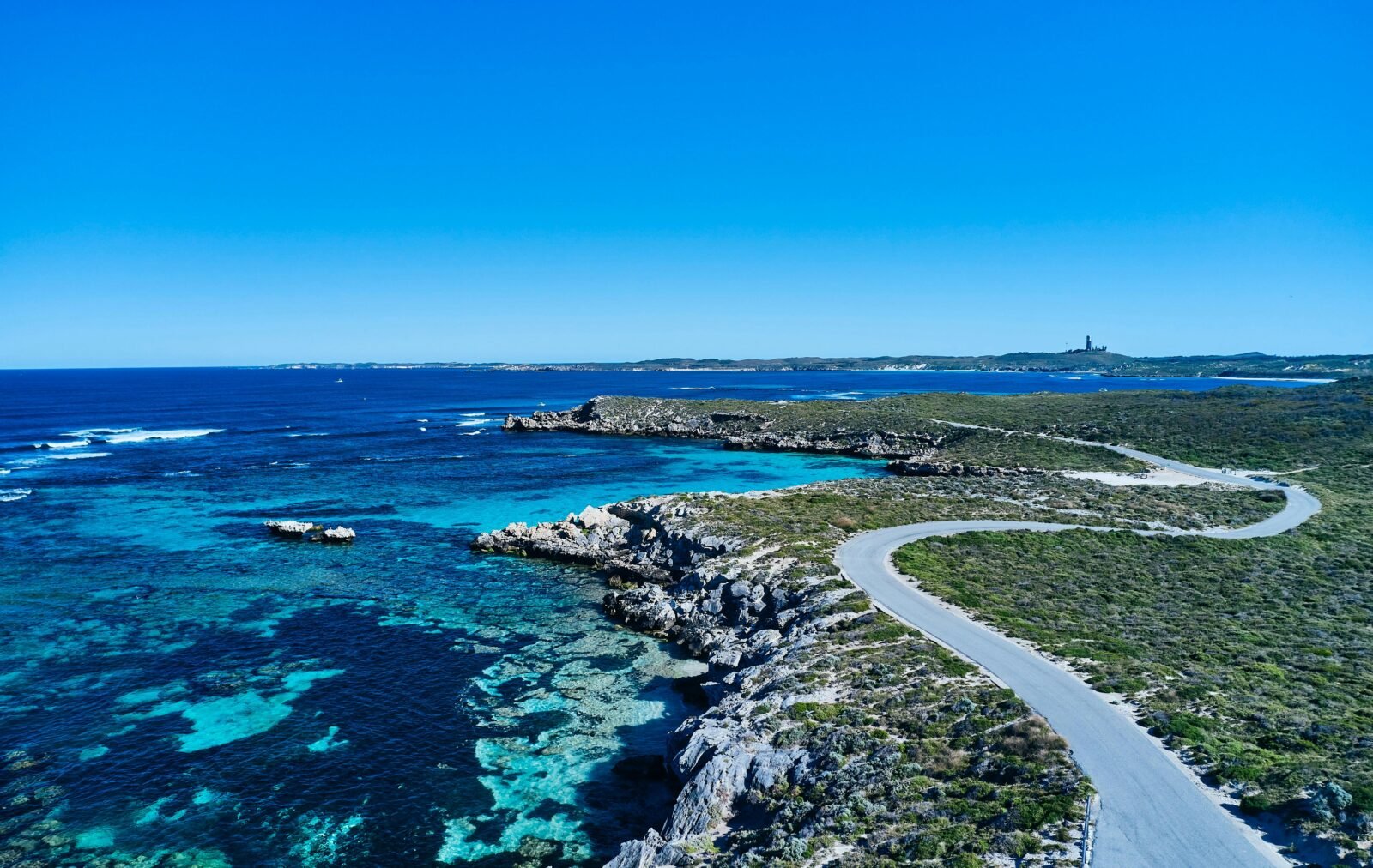Aerial view of road along rugged coastline.